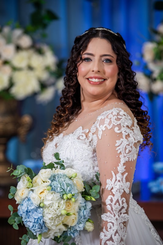 Noiva sorrindo com buquê de flores azuis